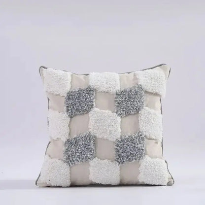 Decorative pillow with textured square patterns on a light gray background