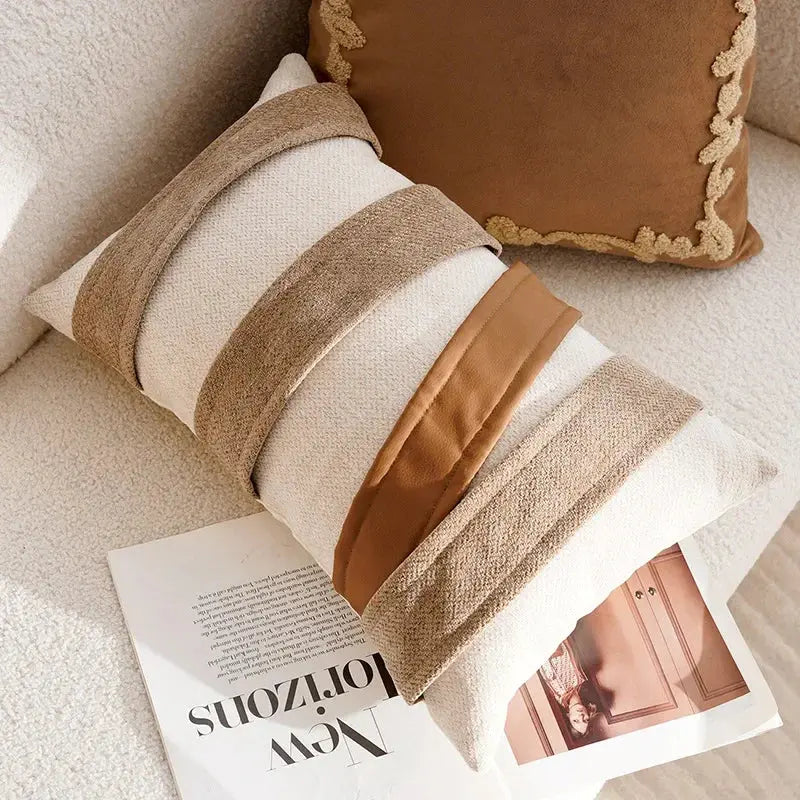 Decorative pillow with brown and beige stripes on a couch next to a magazine.