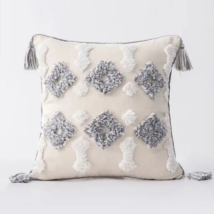 Decorative pillow with geometric patterns and tassels on a light background
