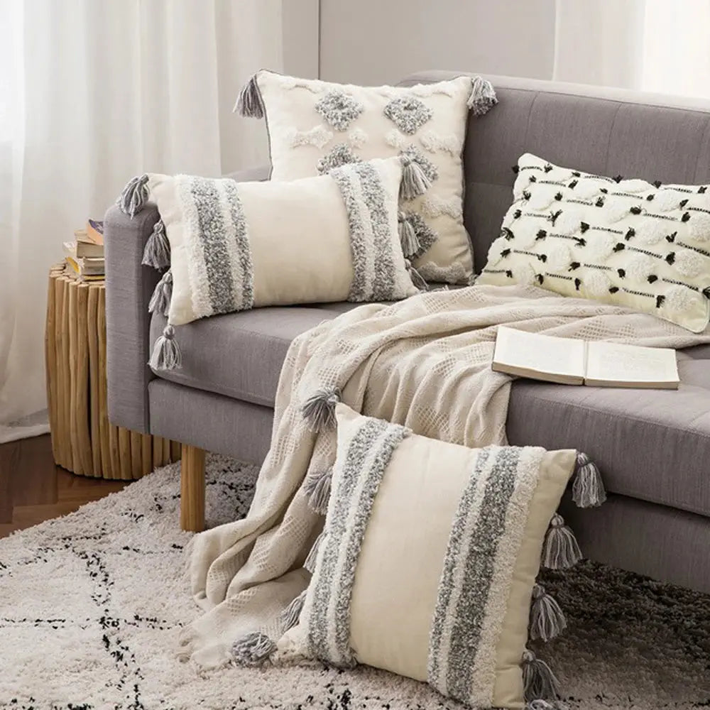Gray sofa with decorative pillows and a blanket in a living room setting