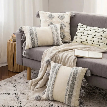 Gray sofa with decorative pillows and a blanket in a living room setting