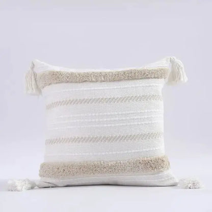 Decorative pillow with striped pattern and tassels on a light gray background