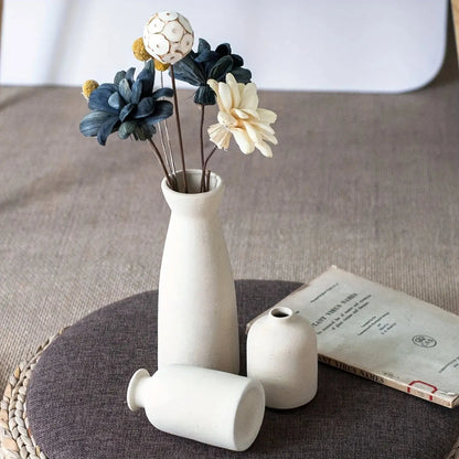 White ceramic vase with flowers on a textured surface