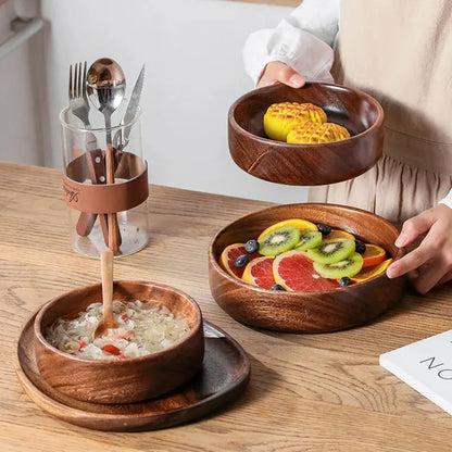 Person holding a wooden bowl with fruit