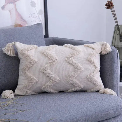 Decorative pillow with tassels on a gray sofa